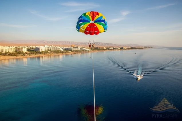 Colorful parasail reflected on Red Sea, with Sharm El Sheikh beaches and luxury hotels in background – unique aerial view.
