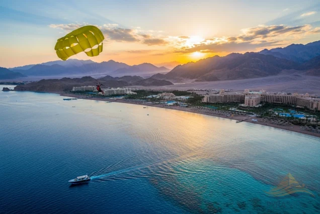 Luxury parasailing in Sharm El Sheikh over the Red Sea at sunset, with PyraSafari. Person soaring above turquoise water and Sharm El Sheikh coastline.