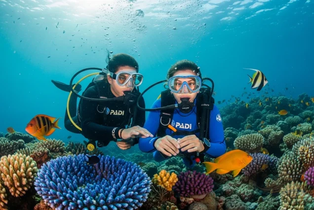 PADI instructor guiding student through underwater skills during Open Water Course in Sharm El Sheikh.