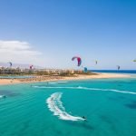 Aerial view of Nabq Bay, Sharm El Sheikh, showcasing vibrant kitesurfing and windsurfing amidst luxury resorts and clear Red Sea waters, the best kitesurfing spot Nabq Bay.